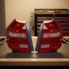 Coppia Fanali Posteriori Destro + Sinistro BMW Serie 1 2007+ – A Led Fondo Scuro sul banco officina